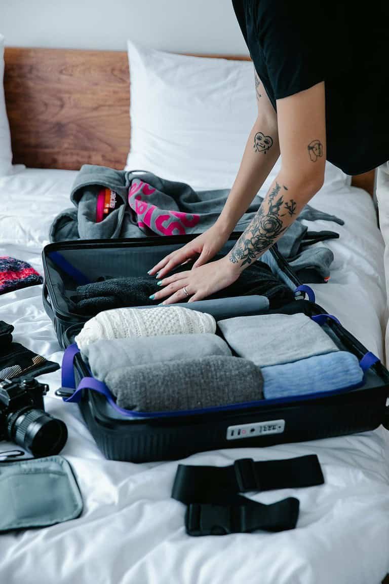 A Tattooed Person Fixing Her Luggage